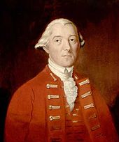 A half-height oil portrait of Carleton.  He faces front, wearing a red coat and vest over a ruffled white shirt.  His hair is white, and is apparently pulled back.